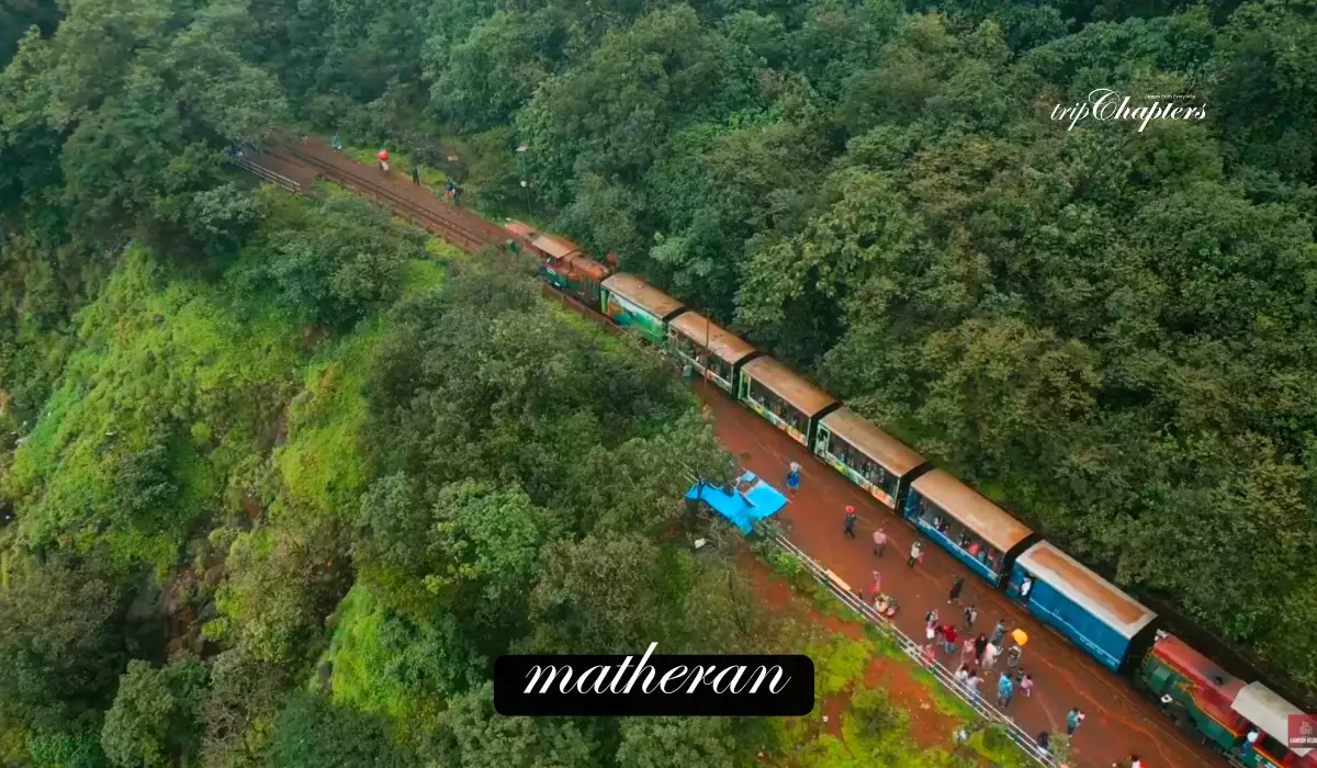 Matheran toy train at a station amidst green hills